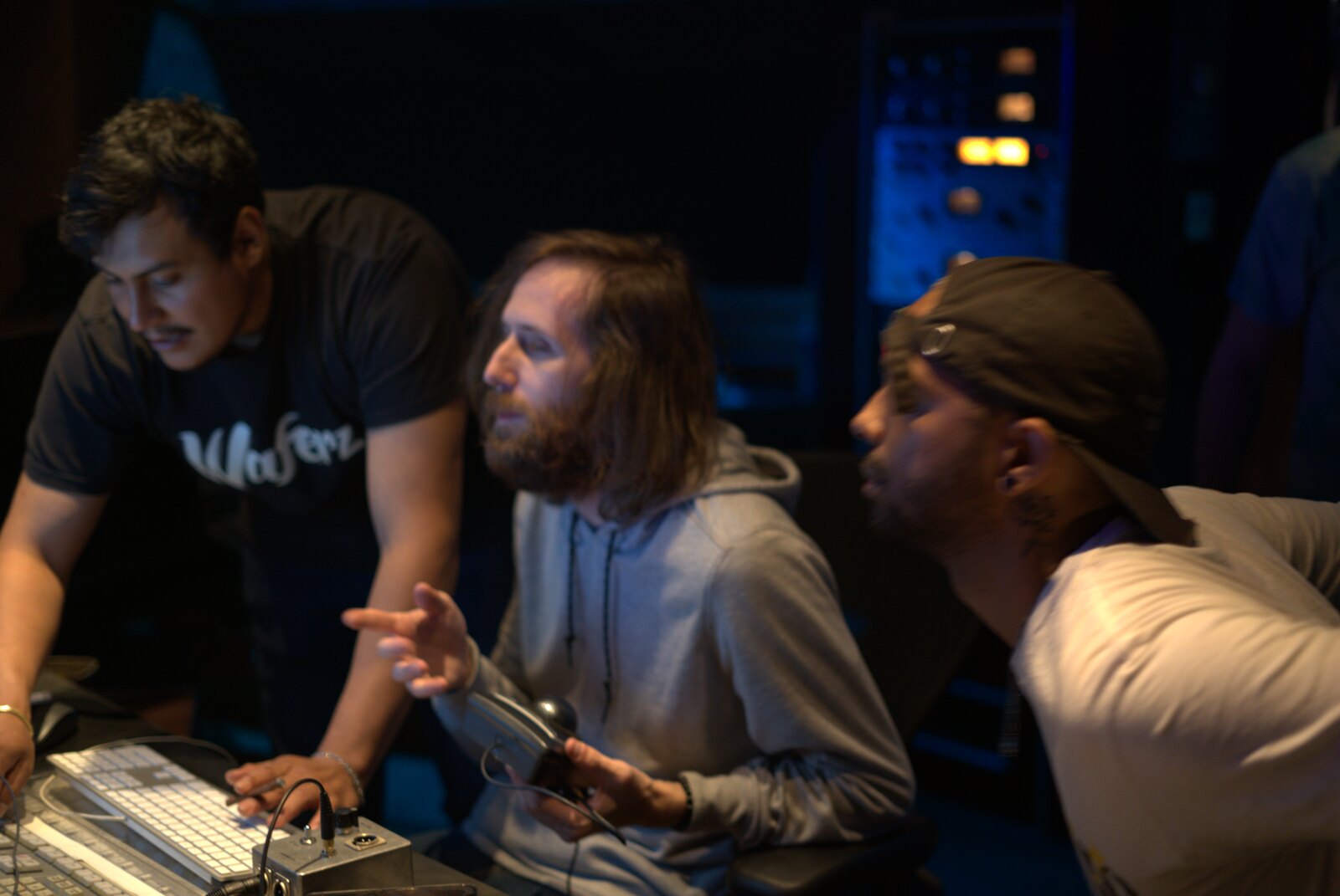 Three collaborators working together in a recording studio