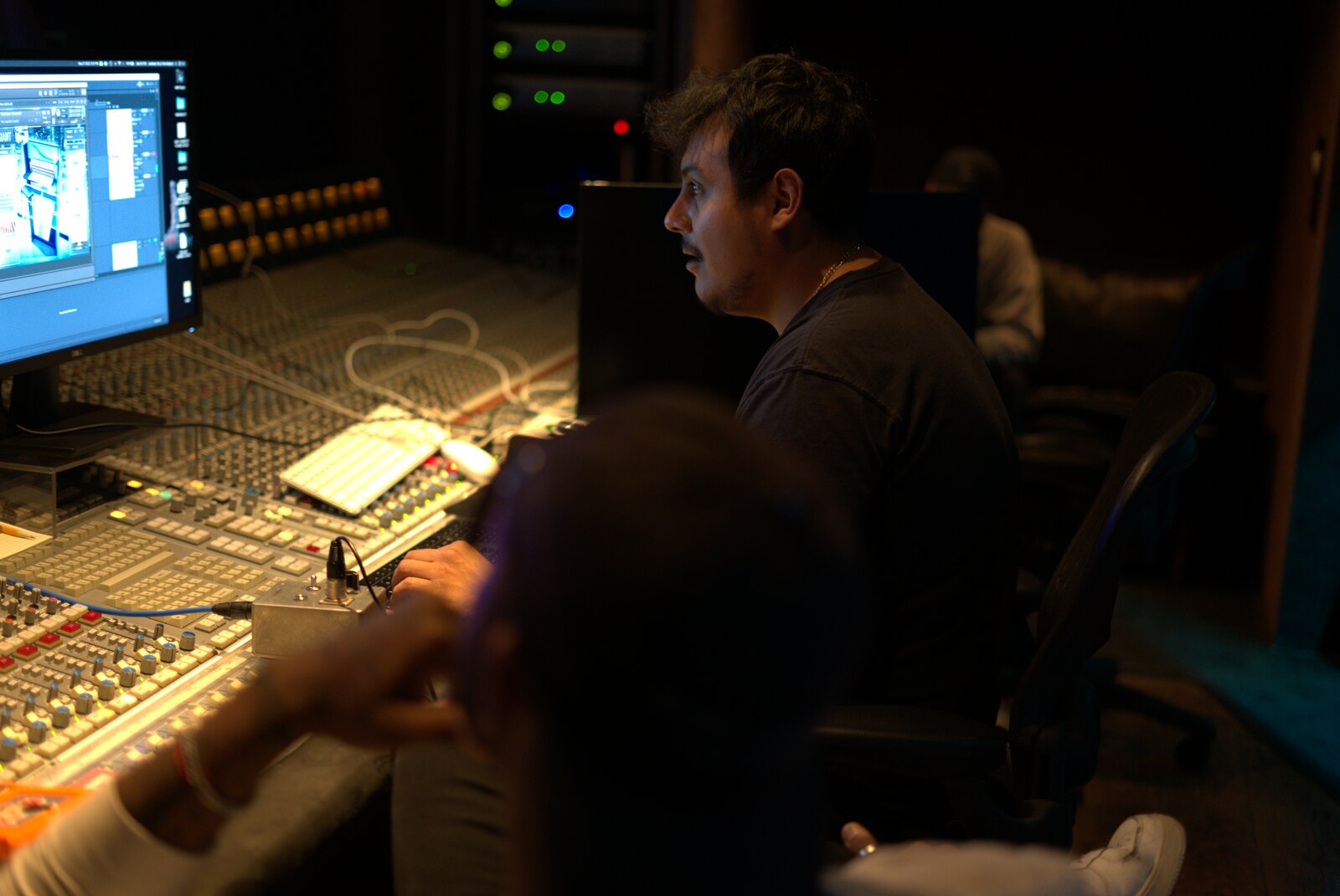 Jonathan De La Torre at a console lit by a monitor